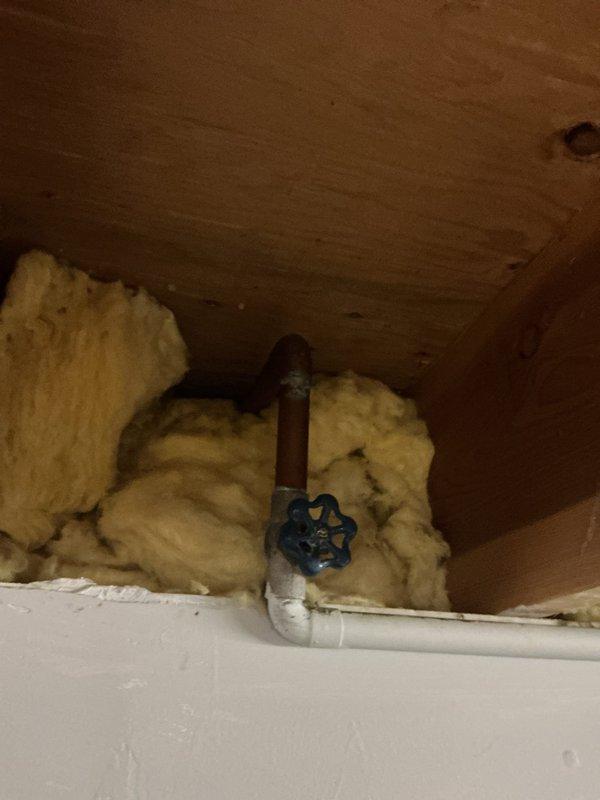 Replaced outdoor spigot with new fixture, installing shutoff valve with blue handle control for interior water isolation. Installed new PVC supply line connection and properly insulated exposed piping with fiberglass insulation to prevent freeze damage during cold weather conditions.