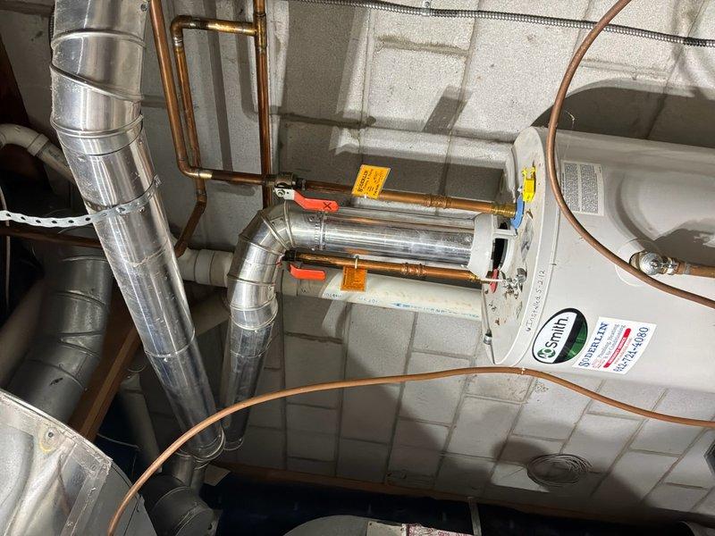 Conducted comprehensive water heater replacement estimate for residential property. Evaluated existing A.O. Smith water heater installation, assessed current copper supply line connections with red-handled ball valves, examined PVC drainage piping configuration, and documented HVAC ductwork proximity to water heater location. Photographed existing installation including all plumbing connections, shutoff valves, and mechanical room layout to provide accurate replacement proposal and ensure proper sizing specifications for new unit installation.