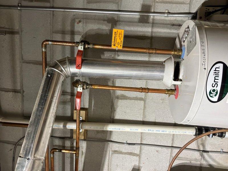 Conducted comprehensive water heater replacement estimate for residential property. Evaluated existing A.O. Smith water heater installation, assessed current copper supply line connections with red-handled ball valves, examined PVC drainage piping configuration, and documented HVAC ductwork proximity to water heater location. Photographed existing installation including all plumbing connections, shutoff valves, and mechanical room layout to provide accurate replacement proposal and ensure proper sizing specifications for new unit installation.