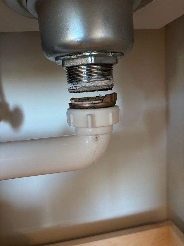 Responded to a kitchen sink leak caused by a broken strainer basket nut on the continuous waste assembly. Replaced the damaged nut, reconnected the drain assembly, and performed thorough leak testing by filling and draining the sink multiple times and running water for over five minutes with no leaks detected. Additionally assessed the laundry tub and faucet for future replacement and provided estimates for that work.