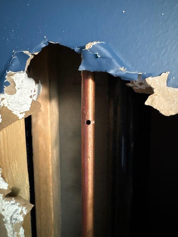 Responded to no water condition at residence caused by city shut-off due to accidental pipe penetration. Customer had pierced copper water line with screw while working on wall, creating active leak. Main shut-off valve was non-functional with spinning handle, preventing water isolation at the property. Replaced failed main water shut-off valve to restore proper water control capability. Repaired damaged copper pipe section by cutting out compromised area and splicing in new piping with appropriate fittings and solder joints. Restored full water service to home and verified system integrity with no additional leaks detected.