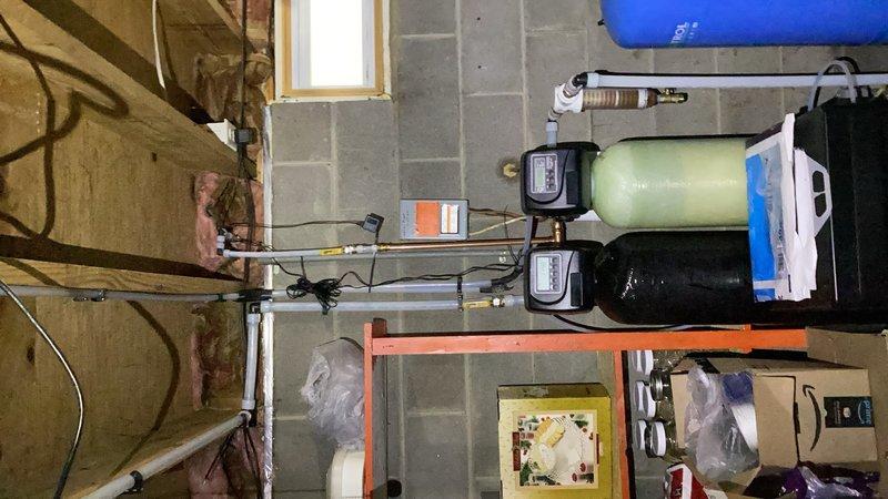 Responded to emergency water softener drain line leak in basement utility area. Upon inspection, identified inadequate PEX fittings at air gap causing regeneration discharge water to leak during softener cycles due to insufficient rigidity in drain connection. Removed flexible PEX fittings and reconfigured drain line using drop elbows (90-degree fittings) and rigid copper pipe to provide proper support and secure connection to drain system. Installation ensures all regenerated water from softener system now properly drains without leakage during regeneration cycles.