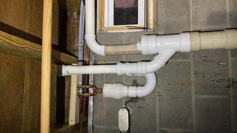 Responded to emergency water softener drain line leak in basement utility area. Upon inspection, identified inadequate PEX fittings at air gap causing regeneration discharge water to leak during softener cycles due to insufficient rigidity in drain connection. Removed flexible PEX fittings and reconfigured drain line using drop elbows (90-degree fittings) and rigid copper pipe to provide proper support and secure connection to drain system. Installation ensures all regenerated water from softener system now properly drains without leakage during regeneration cycles.
