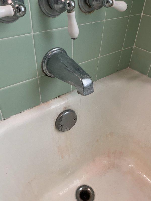 Responded to a leaking shower faucet in a single-family residence with vintage green tile bathroom. Upon inspection, identified active leak at tub spout and cold water valve allowing water passage. Opened wall cavity to access plumbing system, exposing copper supply lines, brass fittings, and shut-off valves behind finished drywall. Assessed valve assembly and determined replacement parts required for proper repair. Completed diagnostic evaluation, documented conditions with photographs, and submitted parts order form to proceed with permanent repair of leaking cold side faucet and tub spout components.