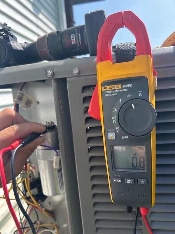 Responded to no cooling complaint on 3-year-old AC unit. Upon inspection, discovered failed dual run capacitor reading 0.8 MFD on a 45 MFD rated component. Customer had previously cleaned heavily impacted condenser coils prior to arrival. Performed comprehensive electrical diagnostics using clamp meter with no additional issues found. Replaced defective capacitor and restored system to normal operation. Conducted complete refrigerant system analysis confirming proper charge levels and satisfactory operating pressures. System tested and verified cooling performance within manufacturer specifications.