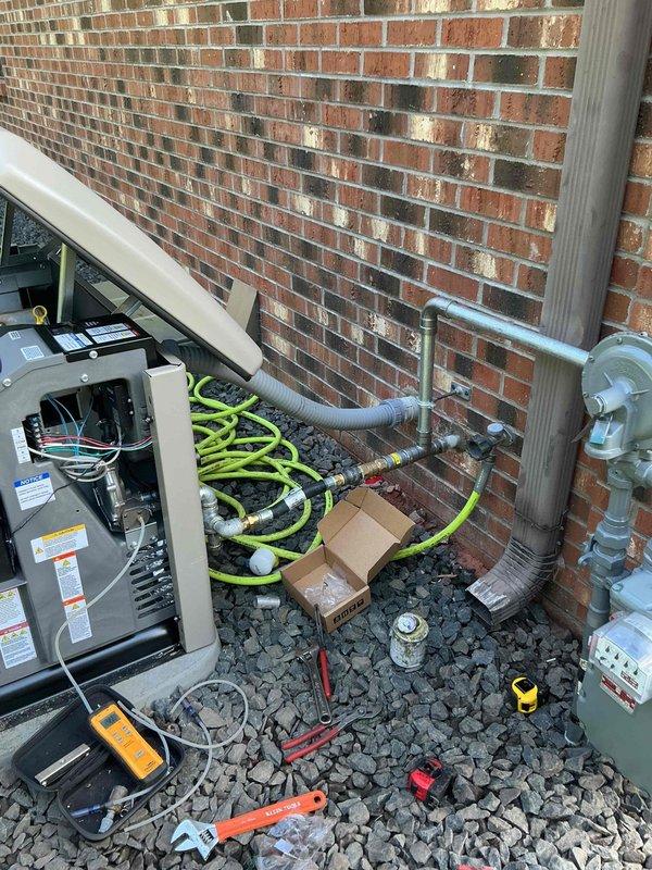 Completed generator installation including electrical service panel integration and outdoor equipment setup. Installed transfer switch panel with main circuit breaker, dual branch breakers, and surge protection device with proper wire routing and conduit connections. Connected generator unit to gas supply line via meter, completed all electrical terminations, and verified system operational status.