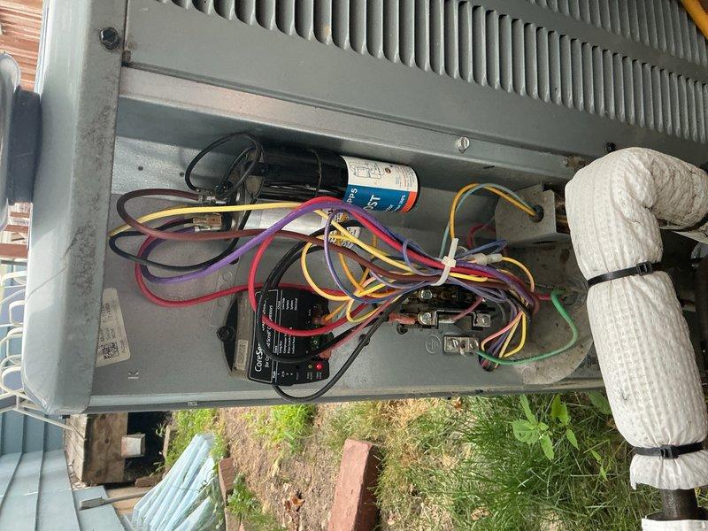 Responded to no cooling complaint on 6-year-old system with intermittent compressor operation and inability to reach setpoint temperature. Upon inspection, found outdoor coil severely restricted with cottonwood debris eliminating airflow through condenser. Tested capacitor and confirmed complete failure with zero reading. Indoor air filter also found heavily soiled and requiring replacement. Compressor safety high-pressure switch had tripped due to inadequate heat rejection from blocked condenser coil. 

Replaced failed capacitor and verified proper electrical values. Homeowner installed new air filter and elected to clean outdoor coil themselves. After capacitor replacement, verified refrigerant charge and delta-T readings within manufacturer specifications. Cycled system through complete cooling cycle with all components operating normally. Unit cooling properly with compressor running continuously and maintaining setpoint temperature.