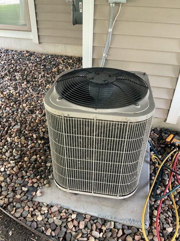 # HVAC Service Completion

Responded to no cooling complaint on 17-year-old residential air conditioning system. Upon arrival, performed diagnostic evaluation and confirmed system was low on refrigerant. System had previously required 2 pounds of refrigerant the prior year, indicating ongoing leak or system deterioration. Given the age of the equipment (17 years old), history of refrigerant loss, and declining reliability, recommended full system replacement rather than additional repairs. Customer approved replacement of aging unit. Removed existing outdoor condenser unit and associated components. Installed new air conditioning system on existing concrete pad. Connected refrigerant lines, electrical wiring, and condensate drain. Verified proper electrical connections at disconnect box and capacitor assembly. Tested new system operation and confirmed proper cooling function. Left work area clean with equipment operational.