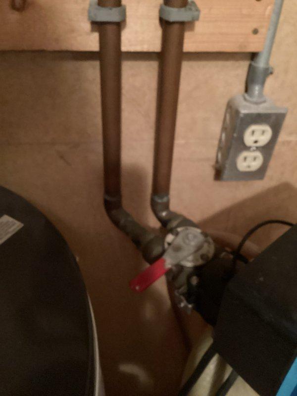 Responded to emergency water leak caused by failed water softener valve that was actively spraying water. Assessed the situation and determined the softener valve was beyond repair. Cut out the malfunctioning water softener unit from the plumbing system and installed a bypass configuration using copper piping to restore water service to the property. The bypass allows continued water flow while preventing further water damage from the compromised softener system.