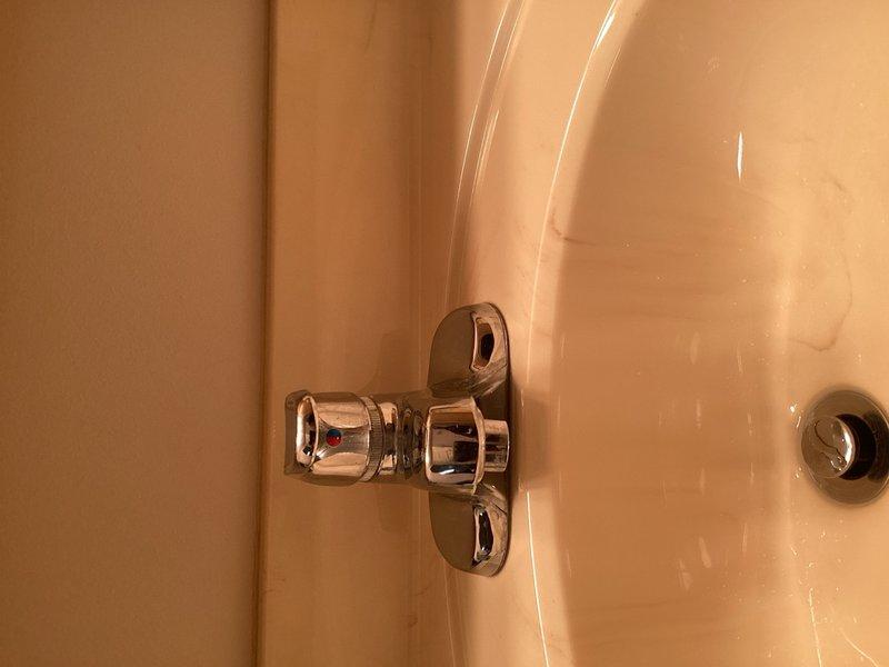 Completed recurring plumbing and HVAC inspection for multi-family property. Evaluated bathroom plumbing fixtures including chrome-plated tub diverter valve and shower components, noting overall good condition with minor wear on chrome finish. Inspected outdoor air conditioning unit, electrical disconnect, refrigerant lines, and PVC condensate drain system with P-trap configuration. Documented findings with photographs and provided written notes and estimates for any recommended repairs or maintenance items identified during inspection.