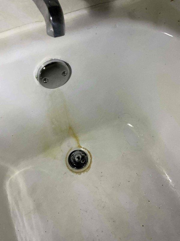 Responded to emergency plumbing call for active leak at bathtub drain assembly requiring immediate attention. Upon arrival, found customer using bucket to collect water from failing tub waste and overflow system. Performed complete replacement of tub waste and overflow assembly per approved estimate. Removed existing deteriorated drain components showing significant mineral buildup and corrosion around drain opening. Installed new standard tub waste and overflow assembly, ensuring proper seal and alignment. Tested system for leaks and verified proper drainage function. Emergency repair completed successfully, eliminating active water leak.