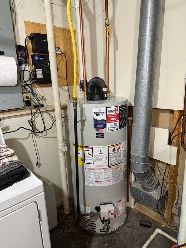 Responded to no hot water complaint at residential property. Upon inspection, found existing water heater leaking from bottom of tank, which caused startup failure and complete loss of hot water supply throughout home. Due to extent of tank failure and safety concerns, determined replacement was necessary. Removed and properly disposed of failed unit. Installed new Bradford White 50-gallon natural gas power vent water heater in utility room. Connected all water supply lines using copper piping with brass fittings, installed yellow-jacketed natural gas line, and configured PVC venting system for power vent exhaust. Verified all connections for proper operation and tested unit for leaks. System fired successfully and began heating water. Confirmed hot water restoration throughout home before completing service.