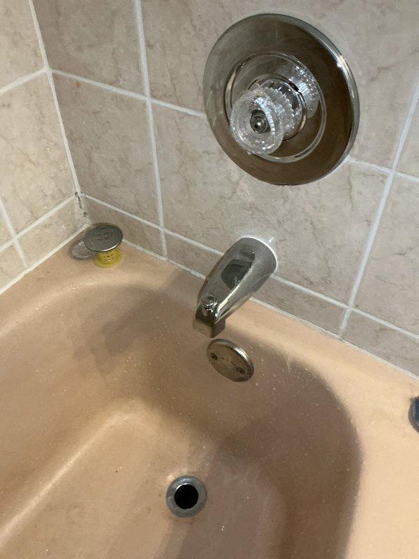 Responded to report of ceiling leak below bathroom in 1950s-era home. Upon inspection, identified leaking bathtub as source of water damage. Diagnosed faulty tub spout and shower cartridge as root cause of leak. Removed and replaced defective tub spout and cartridge with new components, restoring proper function and eliminating leak.