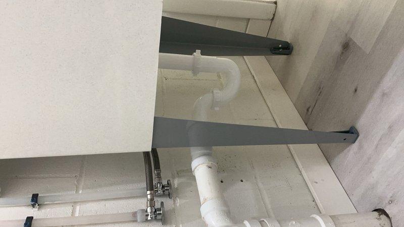 Completed installation of bathroom and utility sink fixtures during scheduled service call. Set and secured brushed nickel three-piece faucet assembly with dual lever handles and central spout on undermount white basin, ensuring proper alignment and water flow. All fixtures tested for leaks and functionality upon completion.