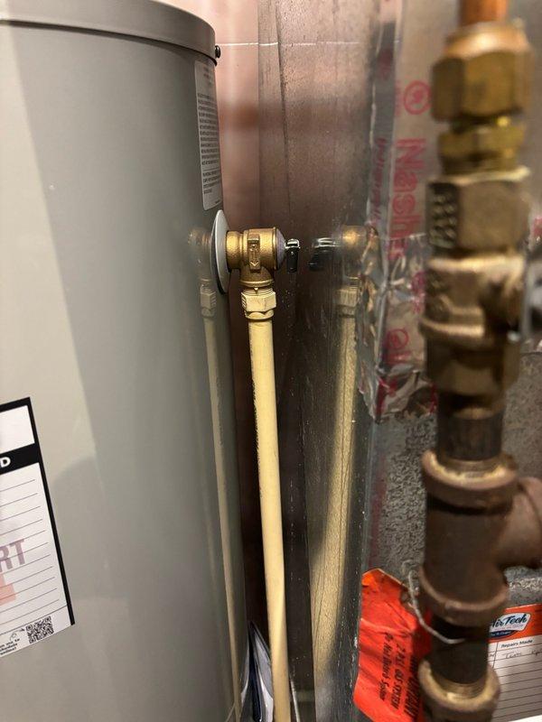 Responded to callback regarding recently installed Bradford White water heater with inaccessible temperature and pressure relief valve. Upon arrival, confirmed relief valve handle was positioned too close to furnace return duct, preventing proper operation and testing. Drained water heater completely and repositioned unit several inches away from ductwork to provide adequate clearance for relief valve actuation. Refilled tank, purged air from system, and relit pilot light. Verified proper burner operation and confirmed relief valve handle now accessible for routine testing and maintenance. System tested and left in full operating condition with no issues found.