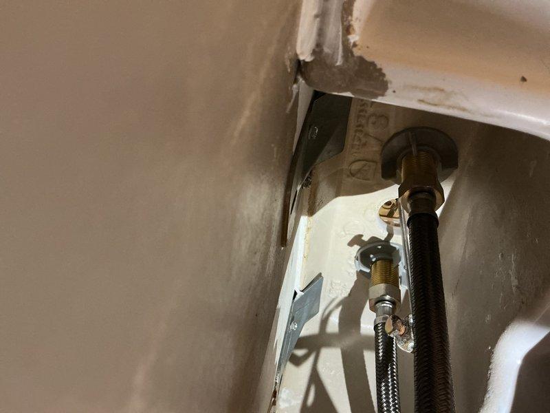 Responded to warranty callback for persistent water leak at pedestal sink installation. Upon inspection, discovered water was not leaking from supply line connections but rather dripping onto the faucet assembly and traveling down the pull mechanism, creating the appearance of a plumbing leak. Verified all water supply connections and shut-off valves were secure and functioning properly with no active leaks present. Determined the issue originated from the faucet unit itself rather than the plumbing installation. Documented findings with photographs showing supply line connections and overall sink assembly. Provided proposal for faucet replacement to resolve the ongoing dripping issue.