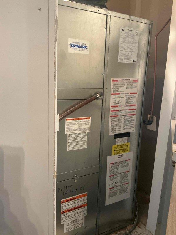 Responded to no cooling complaint on 20+ year old Skymark magic pack system. Upon arrival, found unit running with no blower operation and no airflow through vents. Diagnostic testing revealed system was significantly low on refrigerant charge, resulting in frozen evaporator coil that blocked airflow. Used refrigerant manifold gauges to confirm low charge and identify leak in the system, likely located at the evaporator coil. System operates on obsolete R22 refrigerant. Further inspection of heat exchanger revealed visible rust deterioration with areas rusted through and potential cracks, creating safety concerns. Due to age of equipment, obsolete refrigerant type, refrigerant leak requiring coil replacement, and compromised heat exchanger integrity, recommended full system replacement rather than repair. Scheduled estimate appointment for new magic pack system installation.
