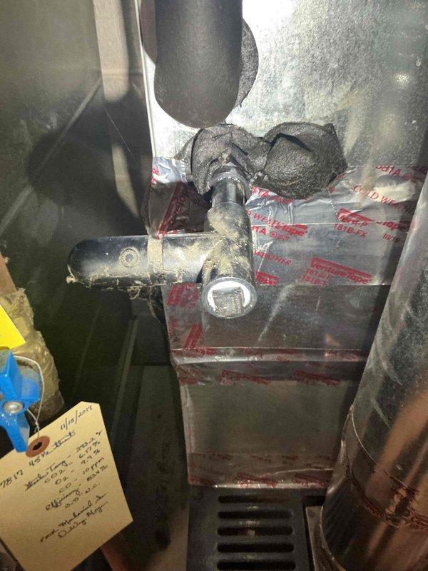 Responded to no-cool complaint on 20+ year old Lennox air conditioning system with water leak at furnace base. Found evaporator condensate drain line completely blocked at drain pan, causing water accumulation. Successfully cleared blockage and verified proper drainage pathway to floor drain. Performed comprehensive system evaluation and discovered inadequate temperature drop across evaporator coil at approximately 12 degrees, indicating cooling deficiency. Upon attempting refrigerant pressure diagnostics, discovered active refrigerant leak at service port Schrader valve with R22 refrigerant escaping, confirming low charge condition. Explained that R22 refrigerant has been phased out and refrigerant-side repairs are no longer performed on legacy systems. Discussed system replacement options and available consultation services for equipment upgrade planning. Customer requested time to consider recommendations. Photos documented existing HVAC equipment configuration and electrical infras