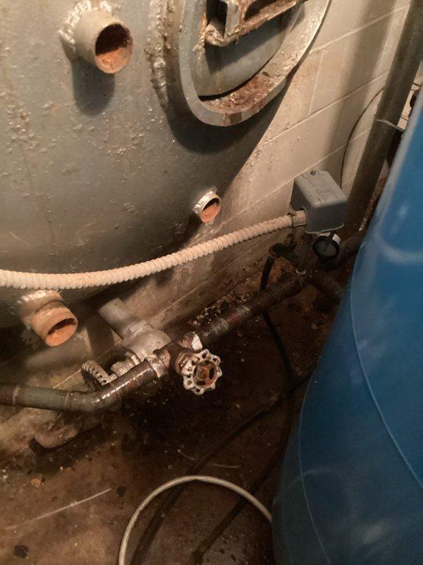 Responded to service call for water shut-off device installation consultation. Conducted thorough site inspection and documented existing plumbing infrastructure, including water heater connections and associated piping. Photographed current plumbing configuration showing corroded water heater with deteriorated metal bands, existing shut-off valve with red handle wheel, copper pipe connections, and flexible supply lines. Assessed cramped utility space conditions and identified optimal installation location for automatic water shut-off device. Evaluated pipe routing options and documented mechanical space constraints to determine equipment compatibility and installation requirements. Provided comprehensive quote for shut-off device installation based on site conditions and necessary materials.