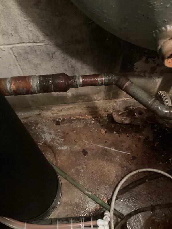 Responded to service call for water shut-off device installation consultation. Conducted thorough site inspection and documented existing plumbing infrastructure, including water heater connections and associated piping. Photographed current plumbing configuration showing corroded water heater with deteriorated metal bands, existing shut-off valve with red handle wheel, copper pipe connections, and flexible supply lines. Assessed cramped utility space conditions and identified optimal installation location for automatic water shut-off device. Evaluated pipe routing options and documented mechanical space constraints to determine equipment compatibility and installation requirements. Provided comprehensive quote for shut-off device installation based on site conditions and necessary materials.