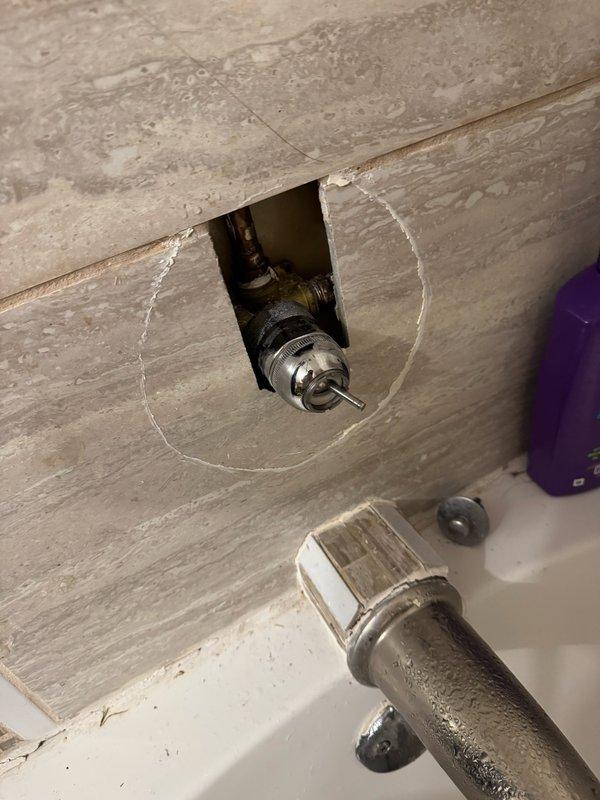 Responded to leaking shower valve located in exterior wall. Upon inspection, discovered valve stem had broken off at pipe connection inside wall cavity. Due to location and lack of access panel, determined that tile removal would be required for proper valve replacement. As temporary solution to restore water service to residence, cut and capped supply lines feeding the shower fixture. Water supply to remainder of home successfully restored. Homeowner opted to defer permanent shower valve repair and schedule comprehensive bathroom remodel estimate to address shower system and surrounding tile work.