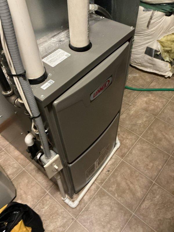 Completed comprehensive tune-up and safety inspection on two-unit HVAC system consisting of a Lennox gas furnace and 6-year-old air conditioning unit. Performed thorough system evaluation in response to reported gas odor during furnace operation, conducted combustion analysis, checked all gas connections for leaks, and verified proper venting through PVC intake and exhaust pipes. Inspected and tested both heating and cooling systems, confirmed clean operation with 3M filtration and electronic air filter in place, measured supply air temperature at 63.3°F, and verified all components functioning within manufacturer specifications with no safety concerns identified.