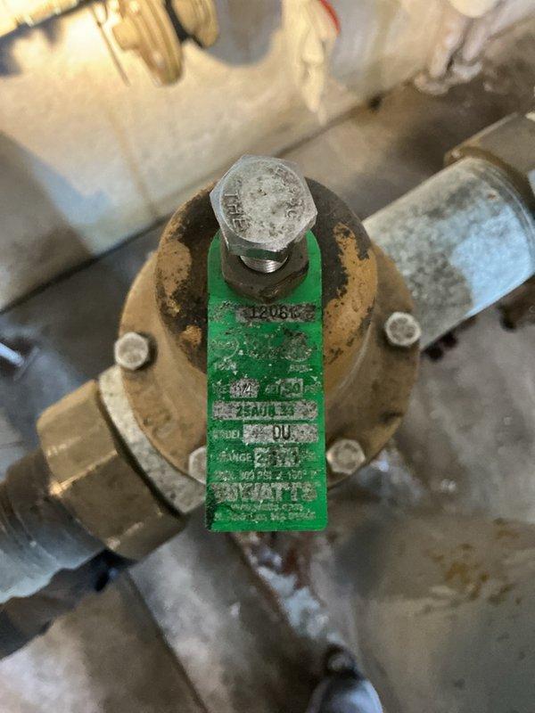 Responded to emergency water leak in building where pipe joint was actively spraying water. Upon arrival, building water supply had already been shut off to stop the leak. Inspection revealed a cracked union on the pressure reducing valve (PRV) assembly, which was the source of the water discharge. The PRV showed significant age and wear, with visible corrosion and deterioration on the brass fittings and surrounding insulation. Documented the damaged PRV assembly and cracked union with photographs showing the weathered condition of the valve body, fittings, and compromised pipe insulation. Prepared estimate for complete PRV replacement to restore proper water pressure regulation and eliminate the leak hazard.
