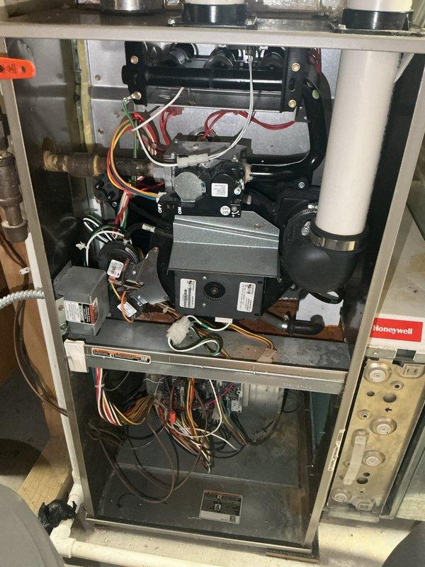 Performed annual heating maintenance on a 14-year-old Carrier furnace and identified critical safety concerns requiring immediate attention. Upon inspection, discovered significant rusting in the combustion cabinet, a cracked inducer draft motor housing leaking condensation, and evidence of combustion gas leakage on both primary and secondary heat exchangers with visible condensation and exhaust marks. Due to the likelihood of carbon monoxide leakage and the extent of deterioration, recommended complete furnace replacement and scheduled an estimate appointment for the customer.