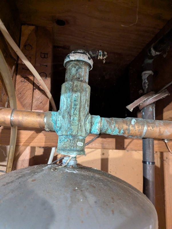 Responded to service call for visible slow leaks in hot water heating system piping prior to heating season. Upon inspection, identified severely corroded copper pipe joints with extensive verdigris buildup and mineral deposits at T-junction fittings in basement utility area. Documented multiple compromised joints showing advanced copper oxidation and active leak points through comprehensive photography. Determined repairs required specialized heating system expertise and coordinated with HVAC department for proper boiler system servicing and joint repair to prevent system failure during upcoming heating season.