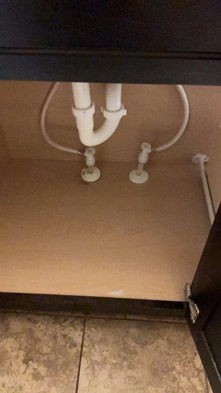 Responded to service call for master bathroom lavatory faucet with stiff operation and malfunctioning drain plug. Assessed center-set chrome faucet with dual lever handles and inspected under-cabinet plumbing connections including P-trap and supply lines. Provided estimates for faucet replacement due to worn internal components affecting handle operation and integrated pop-up drain assembly.
