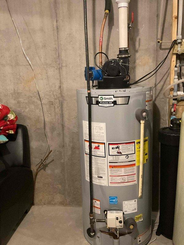 Completed biannual plumbing inspection of residential water heater and plumbing system. Inspected AO Smith water heater including all connections, safety labels, and operational components. Examined plumbing test assembly featuring PVC and copper piping, valves, float mechanisms, drainage basin, and associated electrical controls mounted on wooden framework. Verified proper operation of all plumbing fixtures, connections, and safety devices throughout the system. Documented equipment condition with photographs for service records.