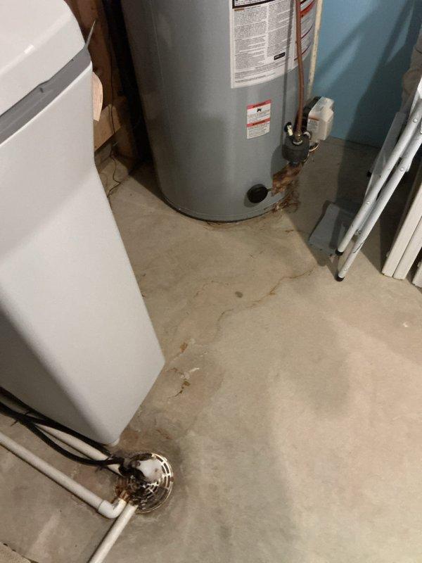 Responded to service call for kitchen sink and shower head leaks. Inspected kitchen sink plumbing and discovered the faucet mounting clip was improperly seated, causing water leakage under the cabinet. Repositioned and secured the clip to manufacturer specifications, resolving the kitchen sink leak. Addressed loose shower head by removing existing connection, applying new thread tape and pipe dope, and properly tightening to eliminate leak. During inspection, identified active leak on 10-year-old 50-gallon AO Smith water heater with visible corrosion on lower tank section. Documented water heater condition with photos for customer review and future service planning.