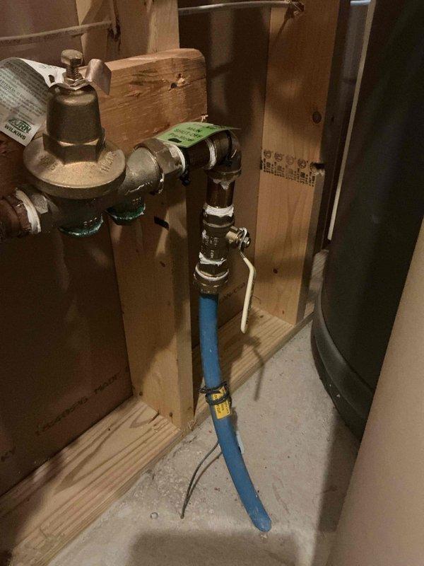 Responded to a service call for a seized ball valve located in the basement before the water meter. Upon inspection, found the main water valve stuck in a partially open/closed position with concerns about a potentially frozen city water main, though no active leaks were present at the time of service. Attempted to remedy the situation by replacing the valve handle, but these efforts were unsuccessful due to the valve being completely seized. Assessed the pressure reducing valve assembly and associated plumbing connections, which included brass fittings and PEX supply lines mounted on the basement framing. Documented the existing plumbing configuration with photographs showing the pressure reducing valve, ball valve assembly, and flexible water supply connections. Provided the customer with a detailed proposal for complete ball valve replacement to restore proper water shut-off functionality and prevent future issues with the main water supply control.