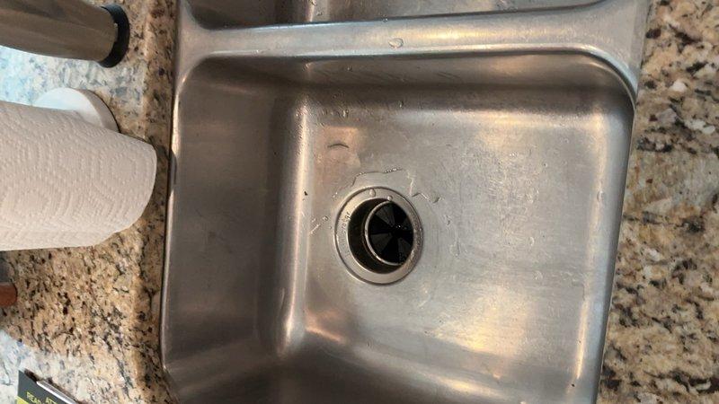 Completed garbage disposal installation in kitchen sink where no previous unit existed. Installed new disposal unit with mounting assembly and drain flange, requiring modification of existing drain piping underneath sink to accommodate the disposal connection. Adjusted P-trap and tailpiece configuration to ensure proper drainage and code-compliant installation.