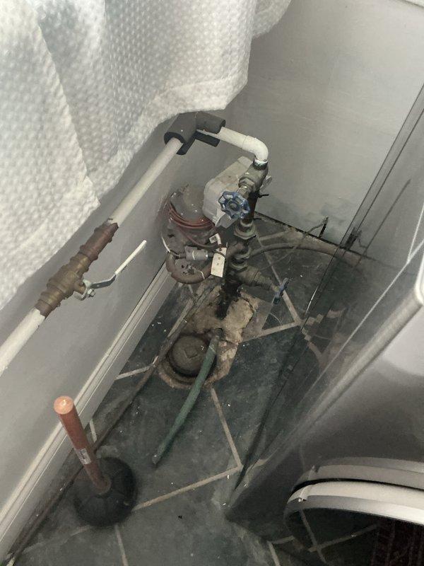 Completed comprehensive plumbing inspection of residential property, examining main water supply system components including pressure relief valve assembly, PVC and copper piping connections, and bathroom fixtures. All systems were visually assessed and photographed for documentation, with particular attention to aging plumbing components showing oxidation on metal fittings and general wear patterns consistent with system age.