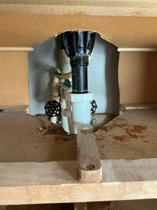 Responded to a water leak originating from a laundry room sink drain pipe. Upon inspection through an existing access opening, identified a loose plastic retaining nut on the drain assembly as the source of the leak. Tightened the plastic nut on the drain assembly to manufacturer specifications, securing the connection and resolving the leak. No water shutoff was required to complete the repair.