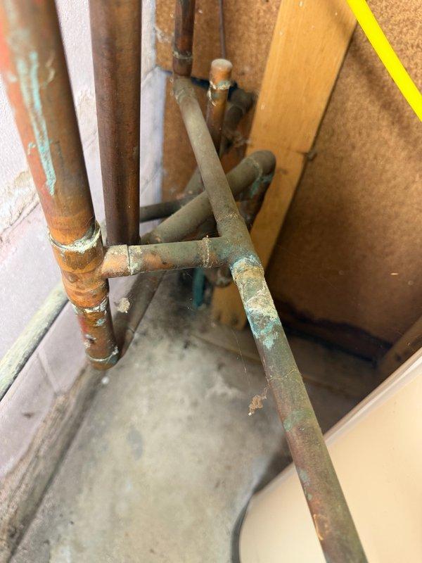 Completed comprehensive Family Rewards plumbing inspection of residential property. Inspected and documented plumbing infrastructure including copper supply lines and drainage systems, noting significant corrosion, oxidation, and verdigris formation on copper piping and fittings throughout accessible areas. Observed aging plumbing components with rust deterioration on metal pipes and connections, documented conditions with photographs for maintenance planning purposes.