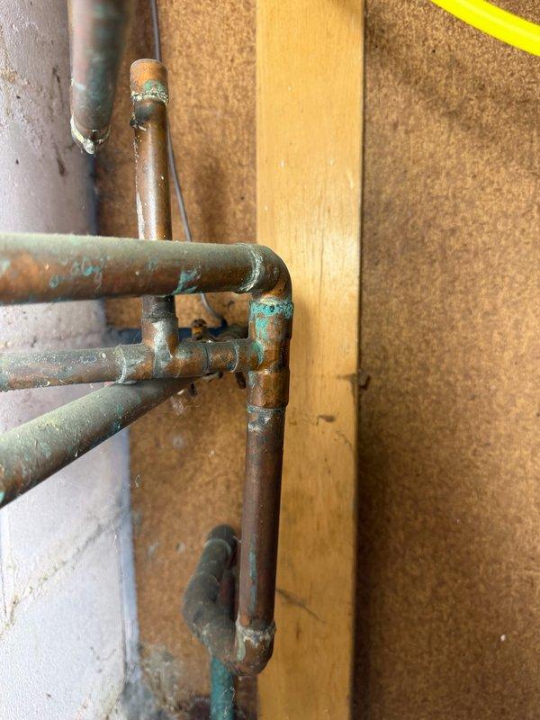 Completed comprehensive Family Rewards plumbing inspection of residential property. Inspected and documented plumbing infrastructure including copper supply lines and drainage systems, noting significant corrosion, oxidation, and verdigris formation on copper piping and fittings throughout accessible areas. Observed aging plumbing components with rust deterioration on metal pipes and connections, documented conditions with photographs for maintenance planning purposes.