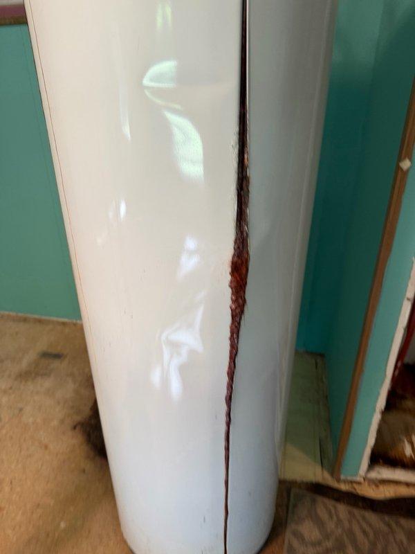 Responded to water heater failure with significant leakage that caused floor damage in utility area. Successfully removed failed tanked water heater unit exhibiting extensive corrosion on copper supply lines and rust staining on tank body, indicating prolonged leak condition. Disconnected water supply connections, drained remaining water from tank, and safely extracted unit from installation location. Assessed and documented water damage to concrete floor surface caused by leaking unit. Site prepared for future water heater installation to be scheduled at later date.