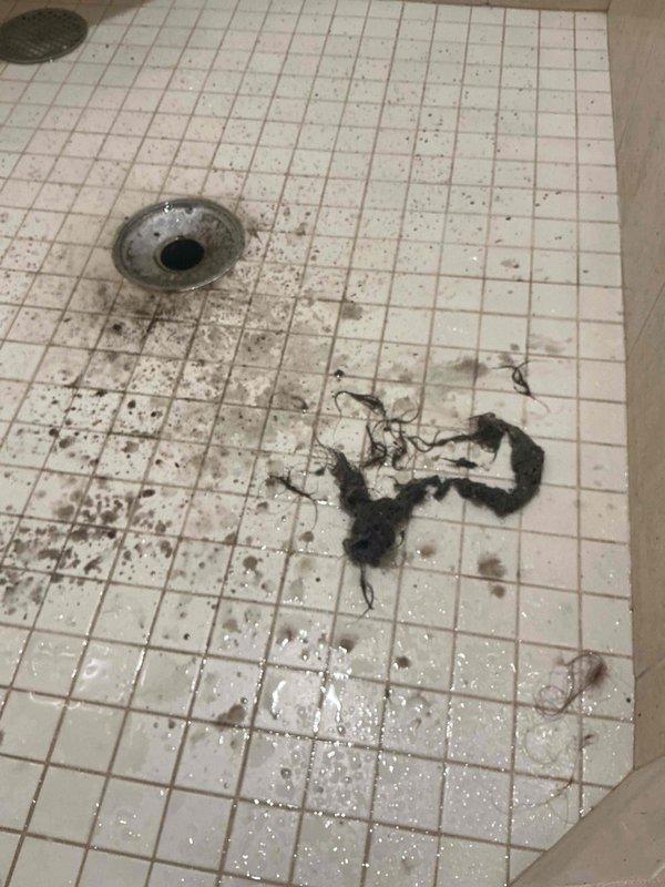 Responded to an upstairs shower drain backup. Upon arrival, performed diagnostic assessment and confirmed the shower was draining slowly and backing up when water was run. Utilized drain cable equipment to clear the obstruction in the shower drain line. Successfully removed a large accumulation of hair and debris that was causing the blockage. Tested the drain by running water and verified proper flow and drainage were restored. Attempted to perform a complimentary main line sewer scope as requested, but encountered camera equipment malfunction that prevented completion of the inspection. A follow-up visit will be required to complete the sewer line video inspection once equipment issues are resolved.