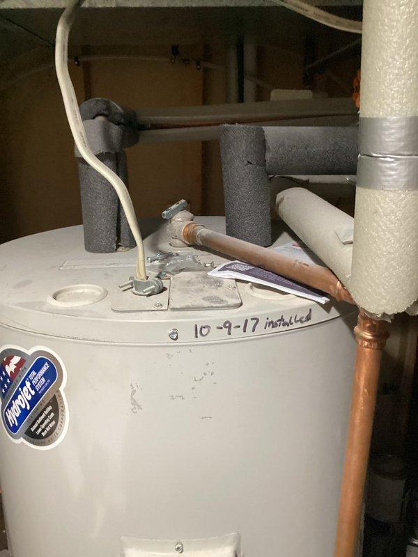 Responded to service call for shower valve replacement in owner-occupied residence. Upon arrival, main water supply was shut off as customer was unable to remove existing valve cartridge from wall assembly. Successfully extracted failed Delta cartridge from shower valve body and installed customer-supplied replacement cartridge. Tested operation and restored water service to home. 

During inspection, noted evidence of significant hard water conditions affecting plumbing system. Offered water quality assessment and treatment options to address mineral buildup concerns, which customer declined at this time. Documented water heater installation date of October 9, 2017, observed during basement utility room access. All plumbing connections secured and system returned to normal operation with no leaks detected.
