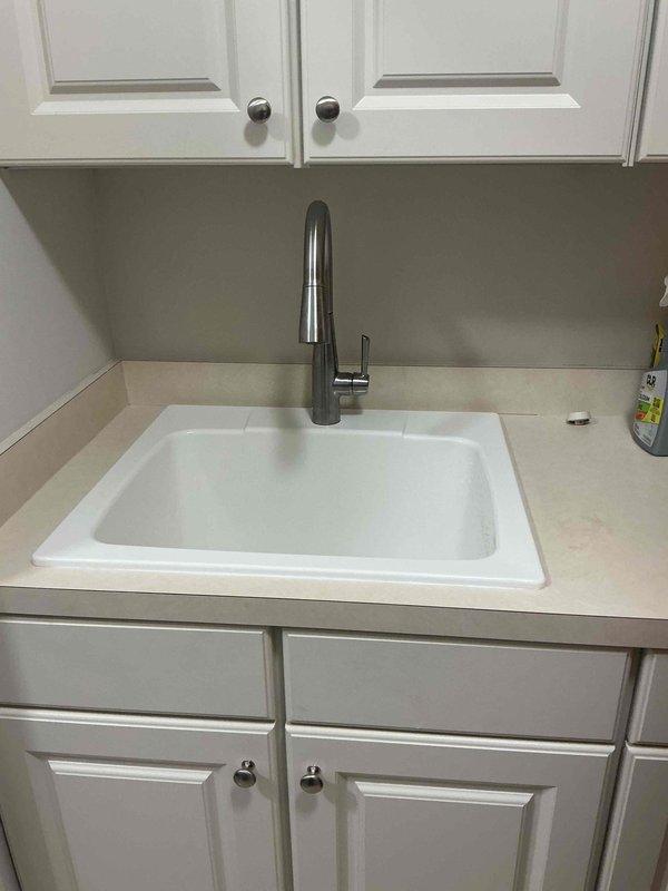Replaced aged laundry tub with new durable unit and installed new shut-off valves for improved water control and longevity. Professionally installed customer-provided faucet, ensuring secure fitting and leak-free operation. Replaced existing PVC drain assembly with new P-trap configuration and installed flexible supply lines with proper connections to resolve leakage issues and enhance functionality of the laundry area.