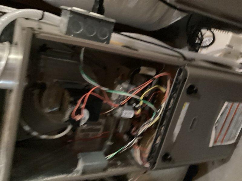 Responded to no cooling call with blank thermostat display. Upon inspection, found improperly installed Dragonfly module with loose wiring connections throughout, including detached C-wire connections. Module was not mounted and control board was unsecured inside enclosure. Remounted control board and temporarily bypassed Dragonfly module to restore system operation. Control board displaying 4-flash diagnostic code indicating sensor replacement required. Recommended replacement of both sensor and Dragonfly module to complete proper repair.
