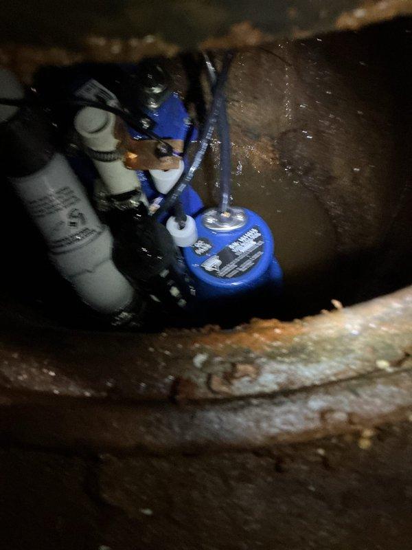 Installed new sump pump with battery backup system in crawl space to provide automatic water removal during power outages and primary pump failures. Utilized existing plumbing connections and electrical routing. System includes integrated battery for emergency operation and float switch mechanism for automatic activation. Unit is now fully operational and tested for proper functionality in below-grade installation.