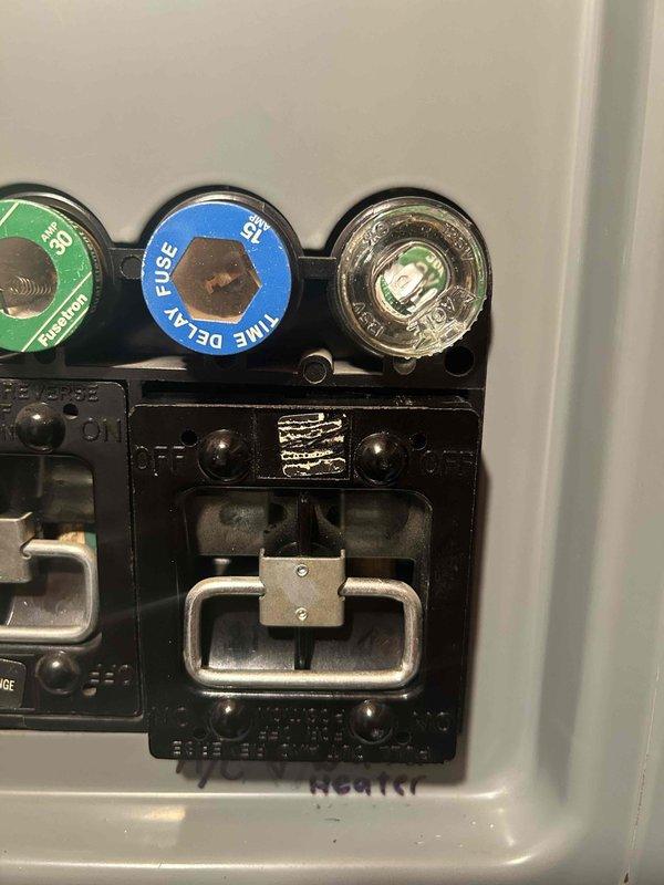 Responded to no-cooling complaint on recently installed central air conditioning system. Upon arrival, confirmed indoor unit operating but outdoor condenser fan not running, resulting in approximately 10-degree temperature differential from setpoint. Diagnostic inspection revealed water heater and air conditioning unit improperly sharing a single 15-amp circuit in electrical panel, causing circuit breaker failure under combined load. Replaced blown fuse and restored power to system. Verified air conditioning unit returned to normal operation with outdoor fan functioning properly. Documented electrical panel configuration with photos showing inadequate circuit capacity for dual appliance load. Advised homeowner that licensed electrician must be scheduled to install dedicated circuit with appropriate amperage for air conditioning unit to prevent recurring breaker trips and ensure code-compliant installation.