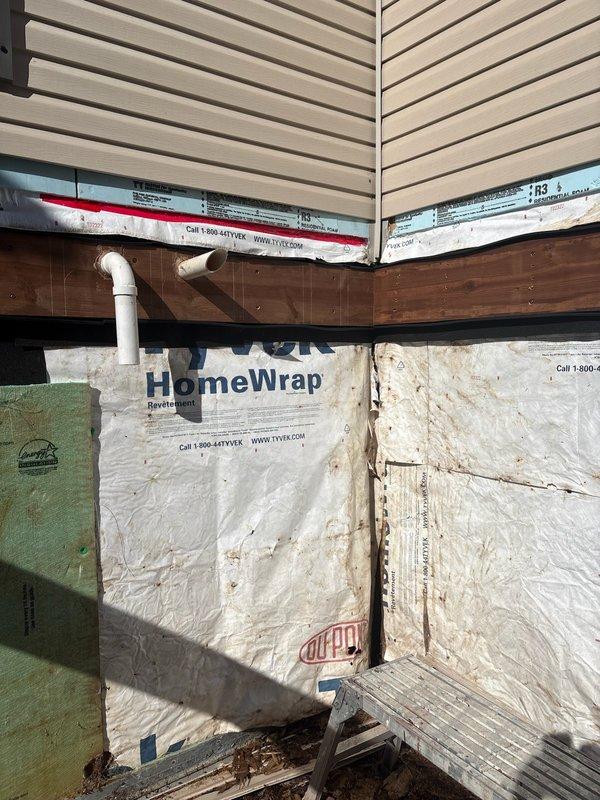 Responded to moisture issue caused by inadequate furnace exhaust venting that resulted in structural damage to building corner. During deck reconstruction with open access to framing, assessed existing HVAC system and determined original exhaust termination was insufficient. Designed and installed new exhaust vent route through alternative wall penetration to eliminate moisture concerns, while existing intake remained in place under deck. Installation included 20-25 feet of 3" PVC pipe with appropriate fittings: four 45-degree elbows, four 22-degree elbows, four couplings, 3x2 reducer, and 2 feet of 2" PVC pipe. Secured piping with J-hooks per code requirements. New exhaust termination properly vented to exterior through building wrap and siding, ensuring adequate clearance and preventing future condensation issues. Two-technician installation completed while framing work provided accessible working conditions.