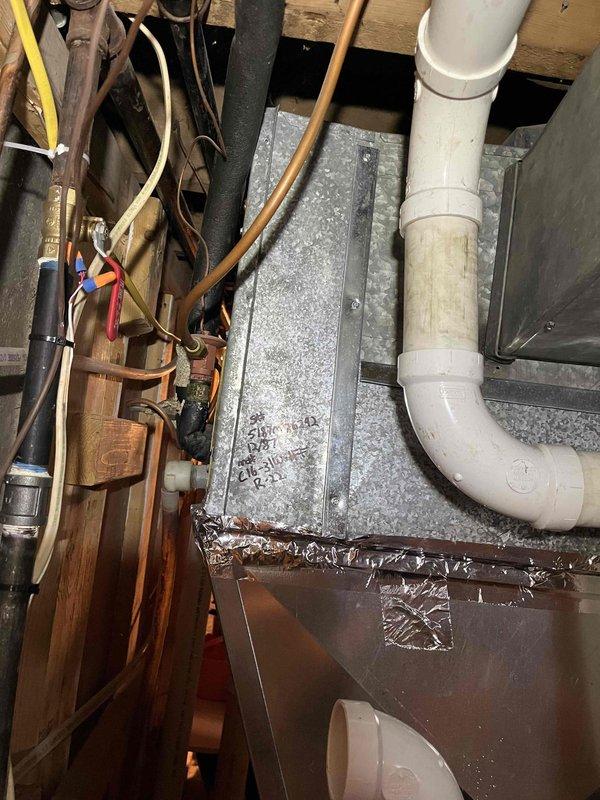 Responded to service call to investigate water condensation issue in furnace area. Upon inspection, located source of water as a rusted metal evaporator coil drain pan on 1987 HVAC system. Drain pan was improperly tilted backward, causing water accumulation. Temporarily propped up drain pan to correct angle and performed water test to assess leak severity. Testing confirmed significant leaking from corroded pan. Explained to homeowner that replacement drain pan for this vintage system would be extremely difficult to source due to age and discontinuation of parts. Documented conditions with photographs showing ductwork, drain pan assembly, and surrounding plumbing components. Recommended full AC unit replacement as most viable repair option given system age and parts availability constraints. Coordinated with sales advisor to schedule equipment replacement quote.