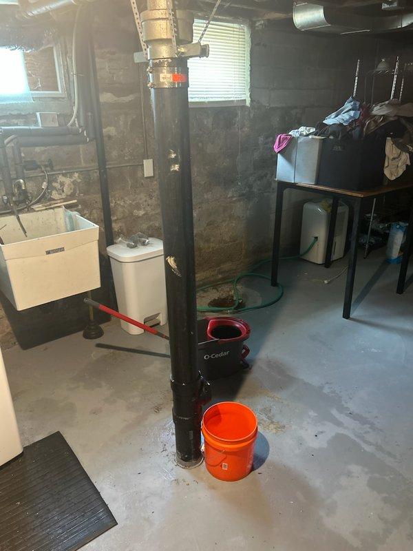 Responded to water leak in basement. Upon arrival, identified active plumbing leak with water still on for the house. Investigated lavatory drain system and determined slow drainage was creating back pressure causing tub overflow. Assessed basement plumbing configuration including water treatment system and vertical pipe assembly. Documented existing conditions with photographs showing utility area layout, sink connections, and mechanical systems. Provided estimate for drain cleaning service to resolve slow drainage issue and prevent future overflow problems.