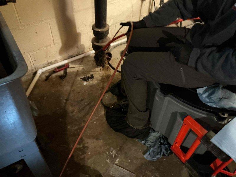 Responded to a mainline sewer backup in the basement of a 1940s residential property. Upon arrival, performed video camera inspection which revealed a significant tree root mass at 20 feet causing severe flow restriction and slow drainage. Cabled the entire mainline sewer from the basement cleanout to 90 feet, successfully removing all tree root obstructions throughout the line. Conducted follow-up video inspection to verify complete root removal and proper flow restoration. Determined the mainline exits through the rear of the property. Captured video documentation of the sewer line condition for future mainline liner estimate consideration. All drainage restored to normal operation upon completion.