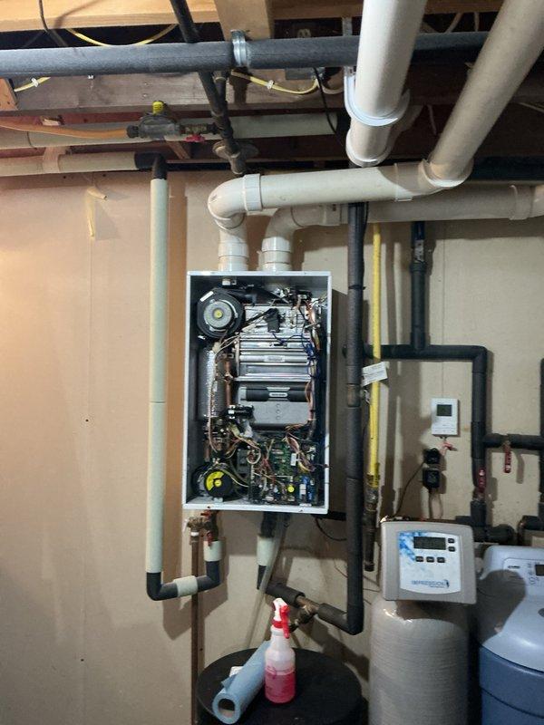 Responded to emergency service call for tankless water heater triggering carbon monoxide detector in basement. Upon inspection, identified unglued PVC exhaust joint allowing combustion gases to escape into living space during unit operation. Properly cleaned, primed, and solvent-welded the disconnected exhaust joint to restore safe venting. Tested unit operation and confirmed carbon monoxide detector no longer alarming. Customer reported inadequate hot water duration during extended use, indicating potential capacity or performance issues with existing tankless system requiring further evaluation for replacement options.